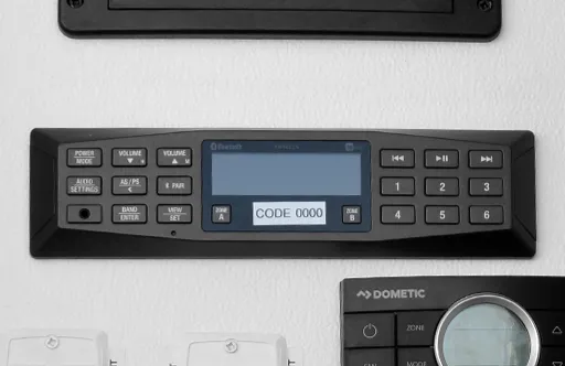 Black electronic control panel with buttons and a screen displaying CODE 0000 mounted on a wall.