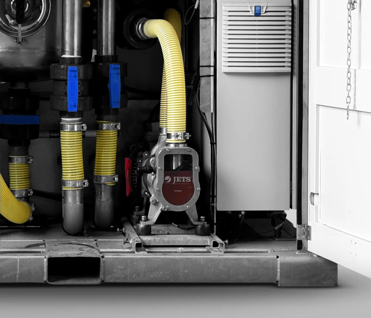 Inside view of industrial machine with yellow hoses, blue valve handles, and a component labeled JETS.