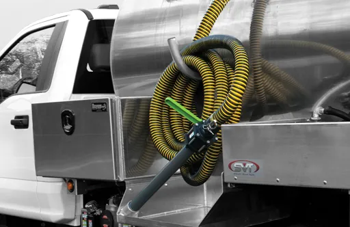 Close-up of a white industrial truck with a metal tank and coiled yellow and black hoses mounted on the back.
