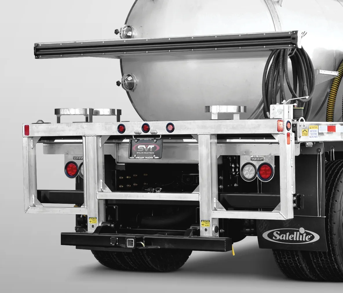 Rear view of a vacuum truck with metal frame, lights, hoses, and Satellite branded mudflap.