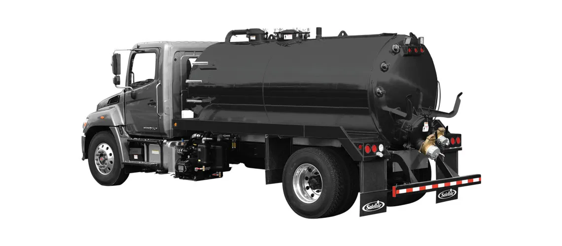 Side view of a gray truck with a large black cylindrical tank on its back for liquid transport.