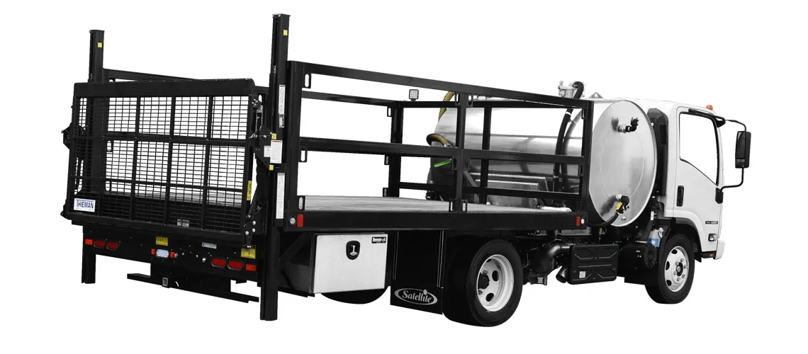 White flatbed truck with black metal side rails and a large cylindrical tank mounted behind the cab.