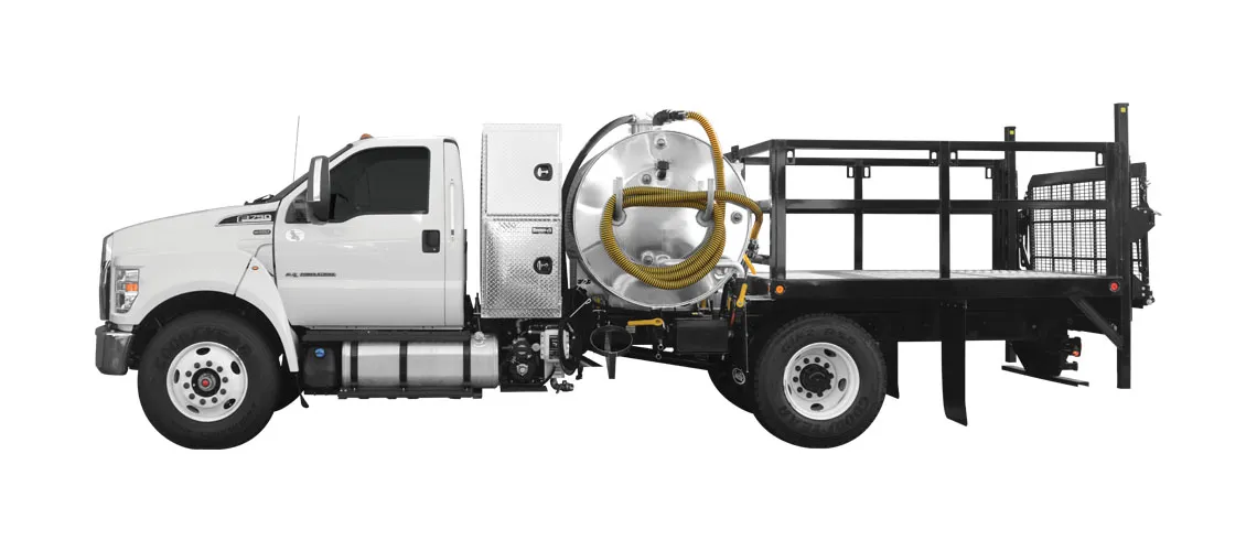 Side view of a white flatbed vacuum truck with yellow hoses coiled on a tank.